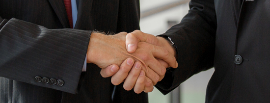 Two people shaking hands in a room.