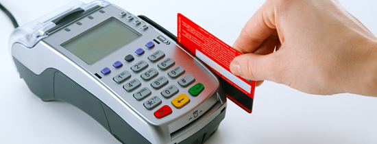 A person holding up their credit card to the reader.